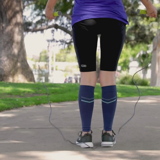 Woman in athletic attire / outfit jumping a rope while wearing blue speed venasense calf compression sleeves