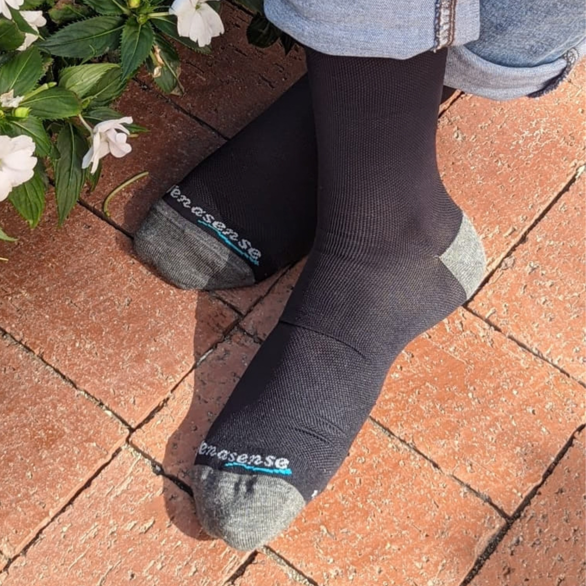 Knee-High Compression Socks in Black – worn with jeans on a brick patio, lifestyle photo