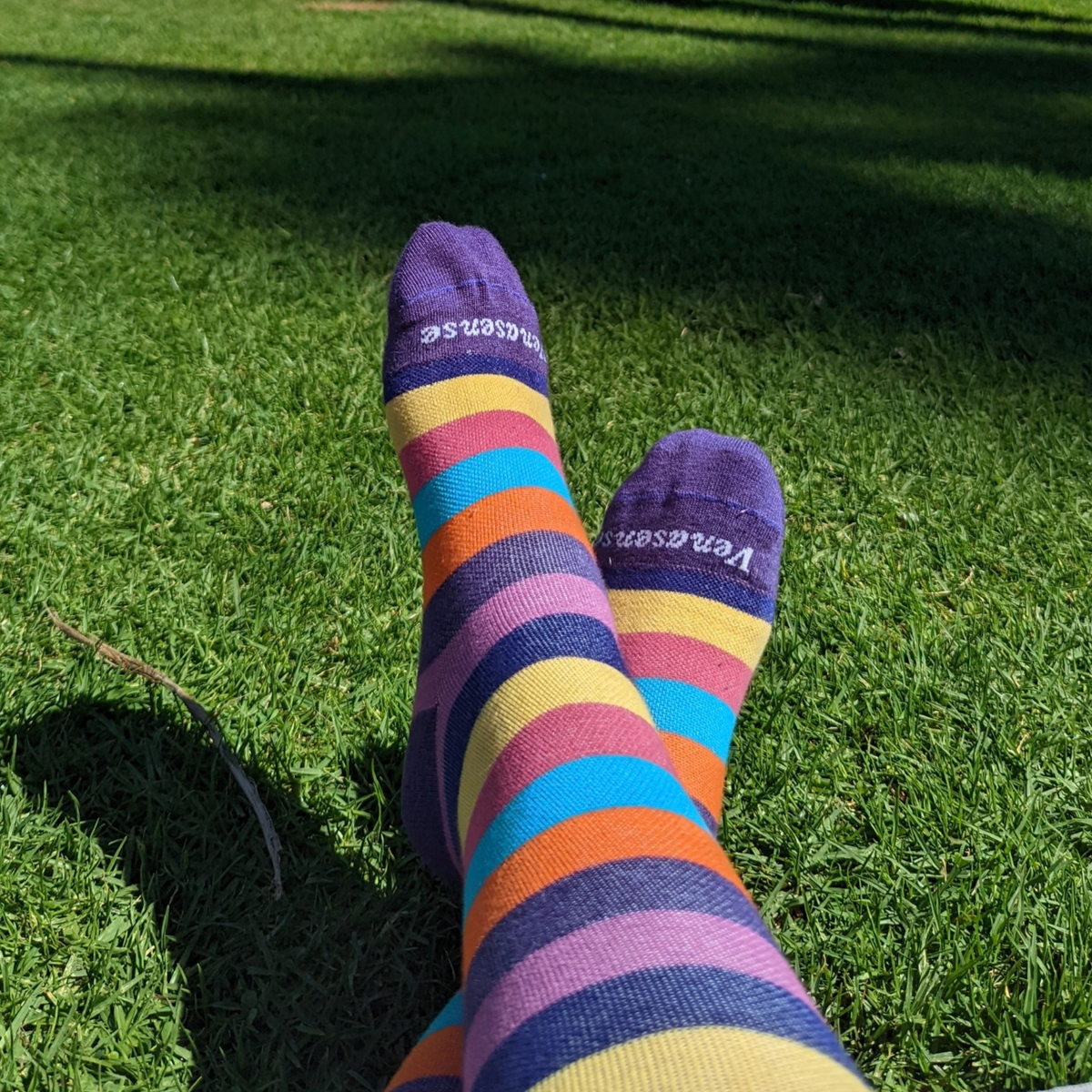 Knee-High Compression Socks in Rainbow Pink – worn outdoors on grass, lifestyle photo